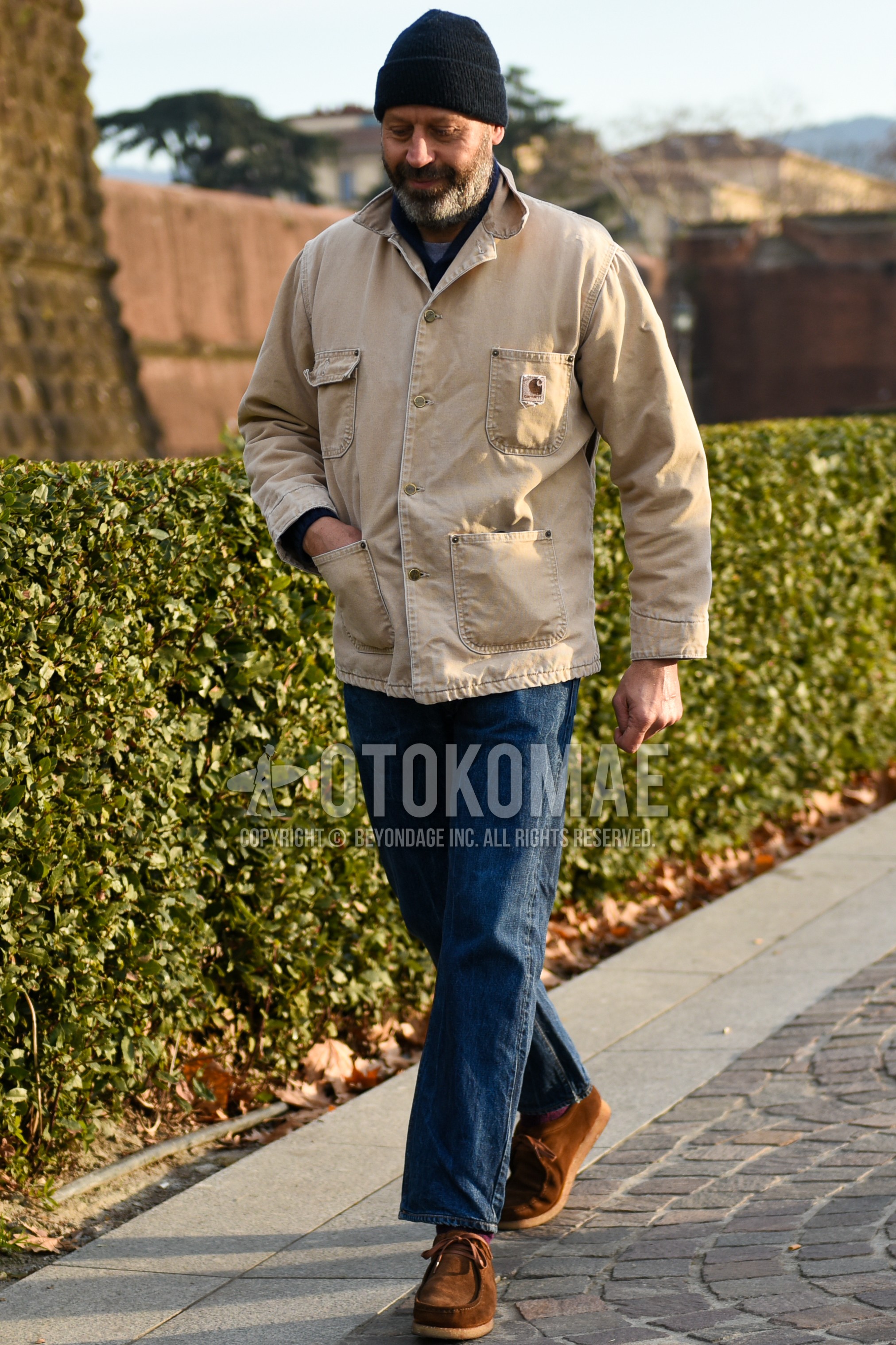 Men's autumn winter outfit with black plain knit cap, beige plain coverall, blue plain denim/jeans, brown u-tip shoes leather shoes.