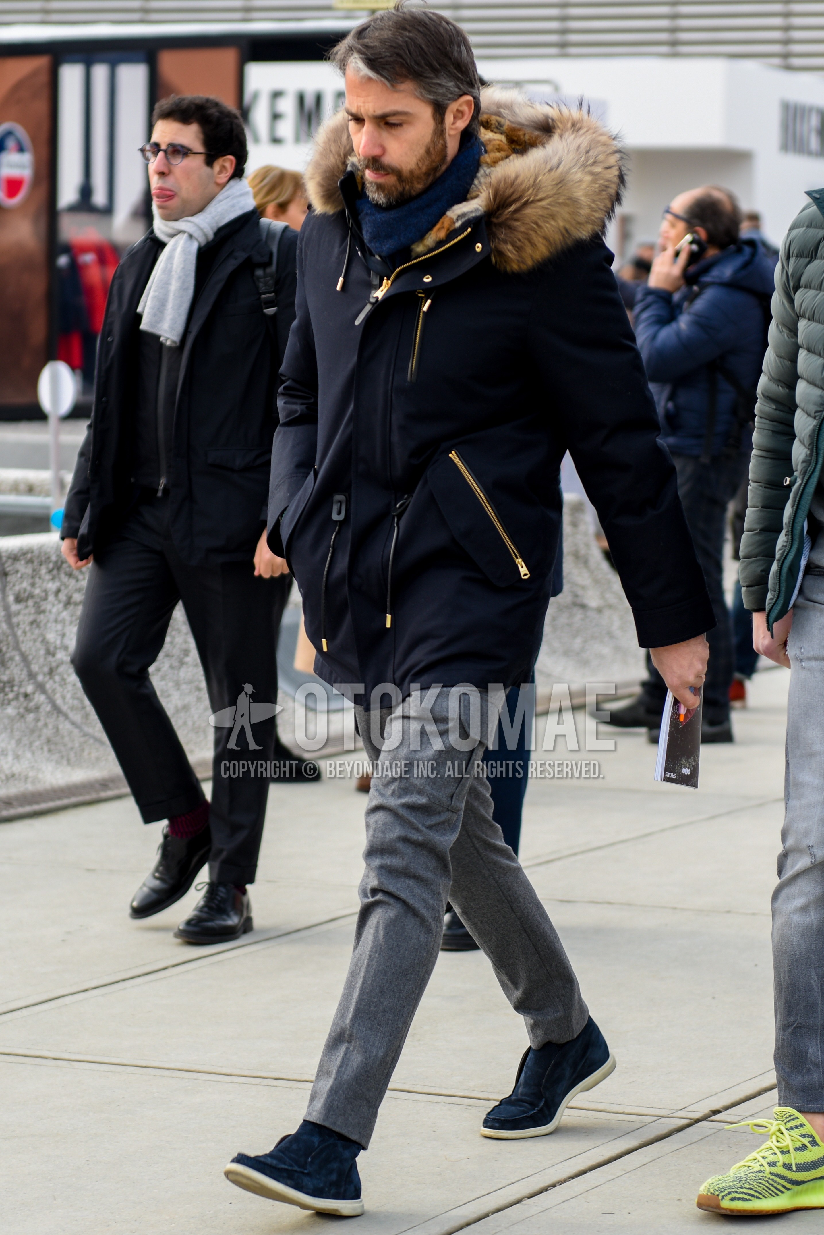 Men's winter outfit with navy plain scarf, black plain down jacket, gray plain slacks, gray plain cargo pants, navy high-cut sneakers.