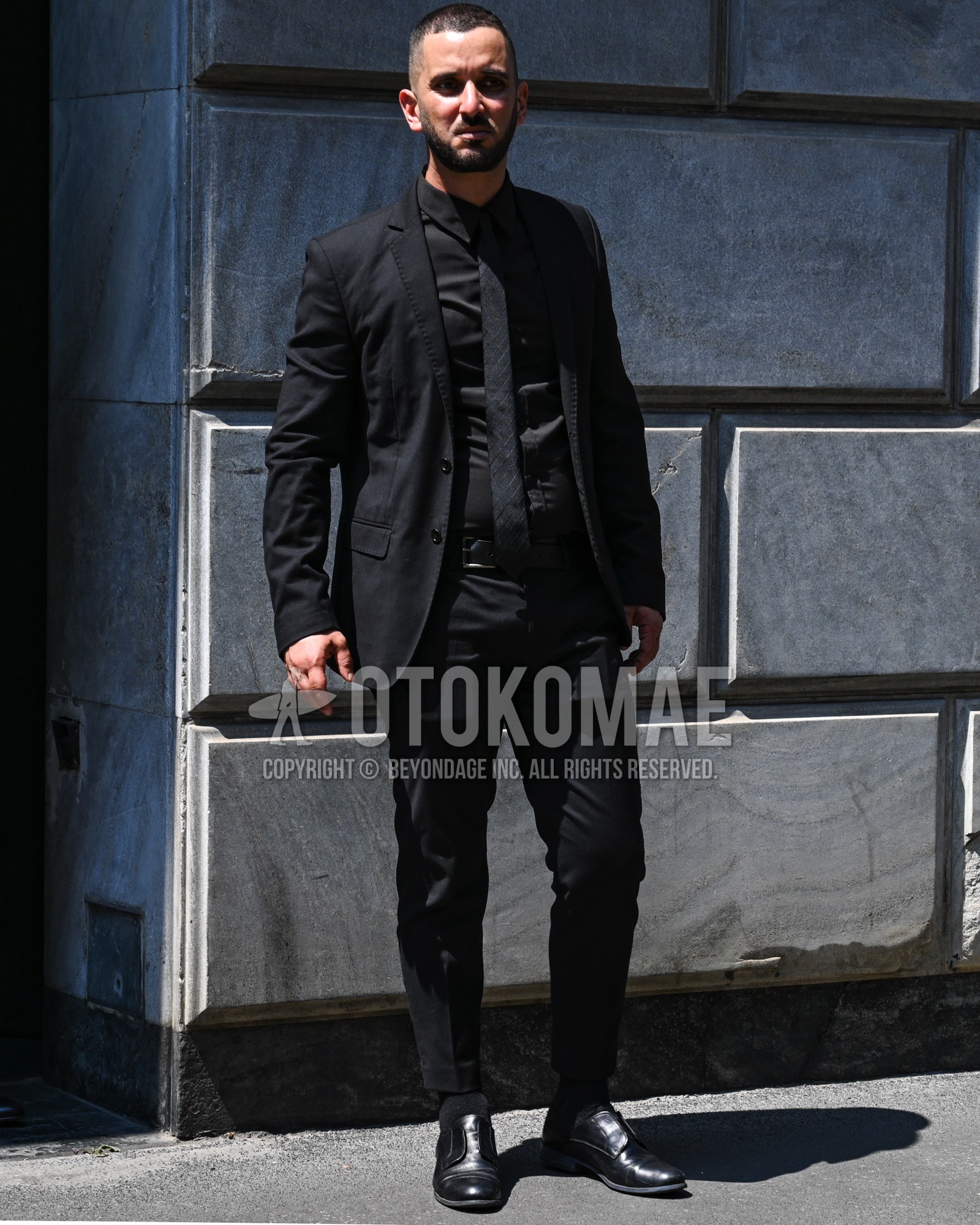 Men's spring summer autumn outfit with black plain shirt, black straight-tip shoes leather shoes, black plain casual setup, black plain necktie.