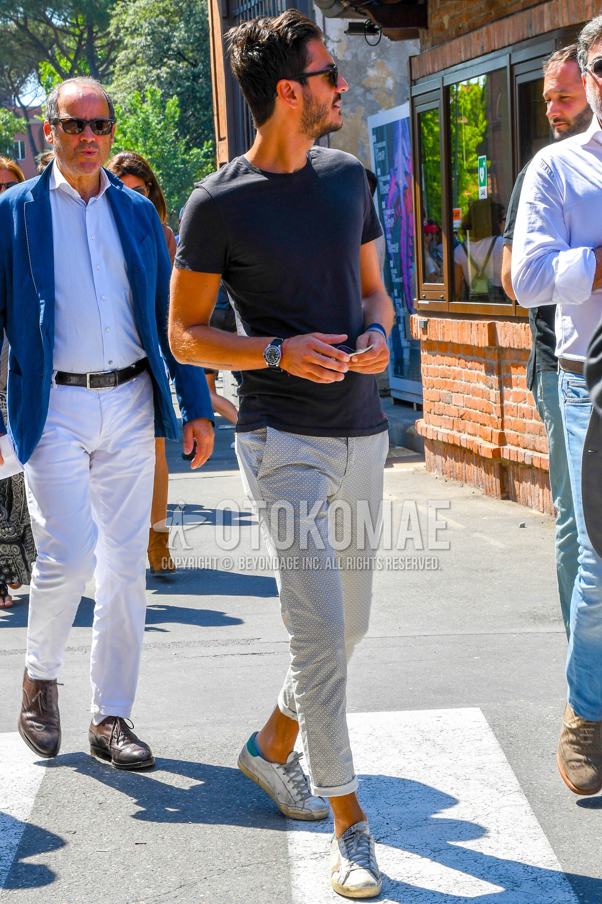 Men's summer outfit with plain sunglasses, black plain t-shirt, gray bottoms cotton pants, white low-cut sneakers.