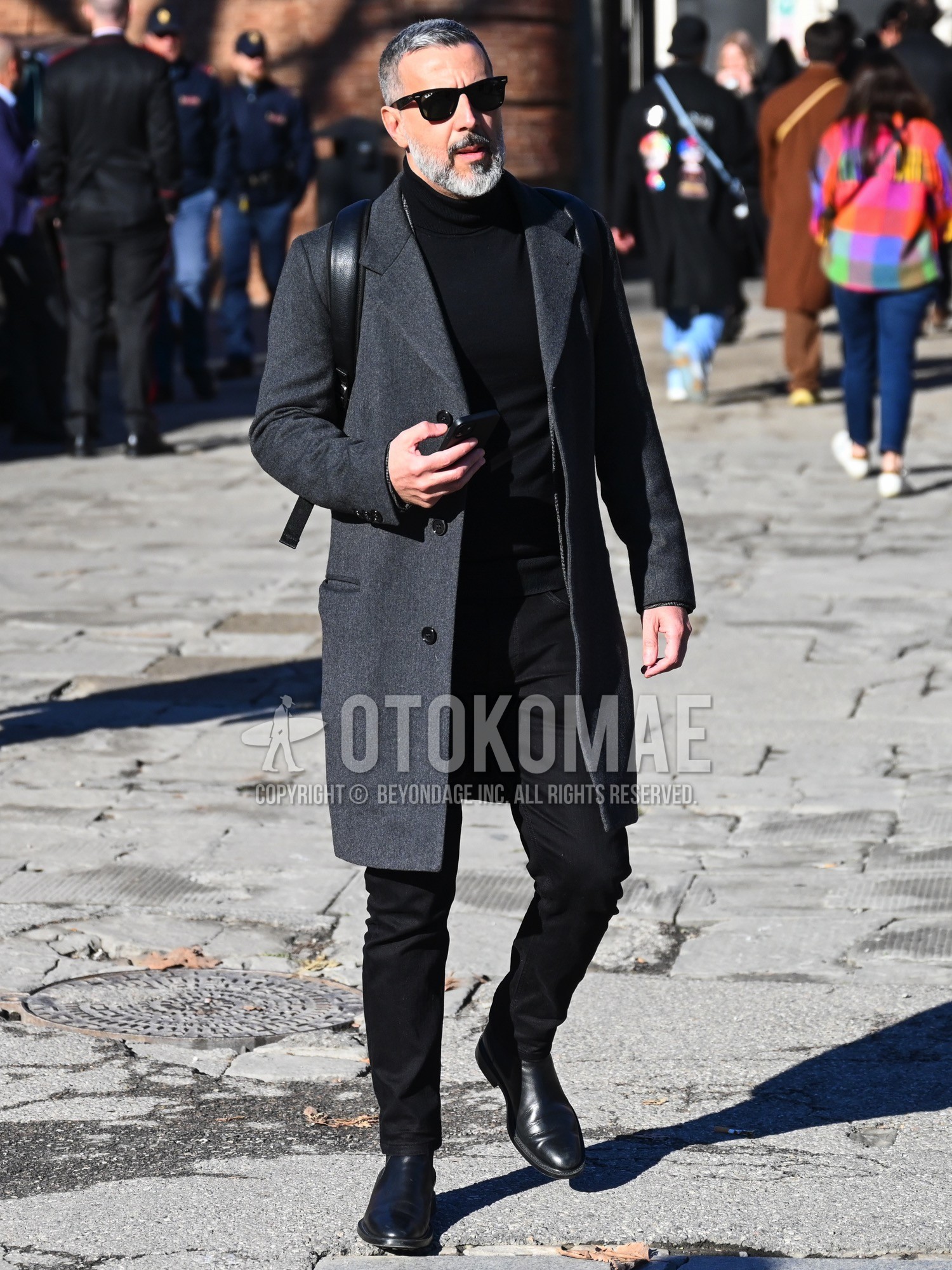 Men's autumn winter outfit with black plain sunglasses, gray plain chester coat, black plain turtleneck knit, black plain chinos, black side-gore boots.