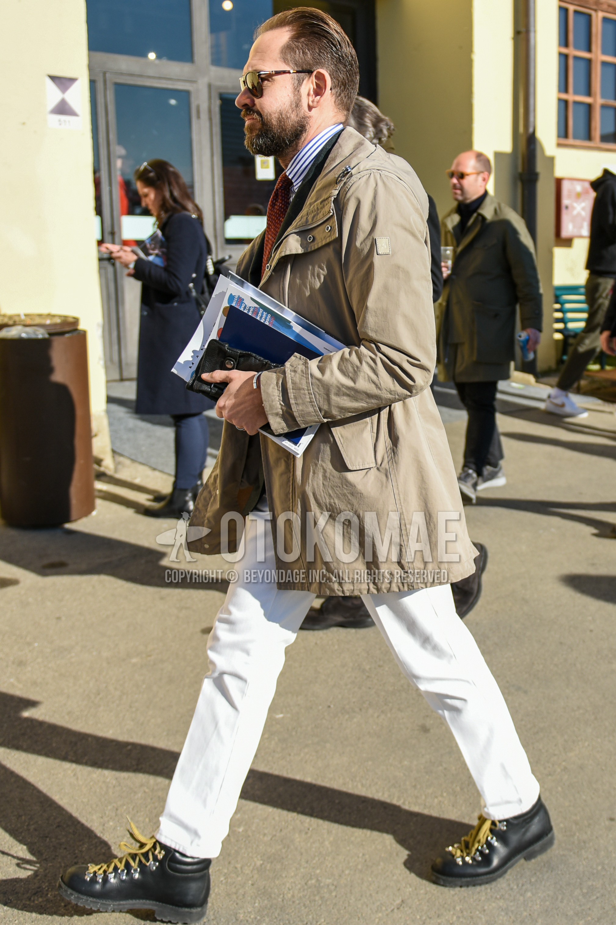 Men's autumn winter outfit with brown tortoiseshell sunglasses, beige plain hooded coat, white blue stripes shirt, white plain cotton pants, black  boots, brown small crest necktie.