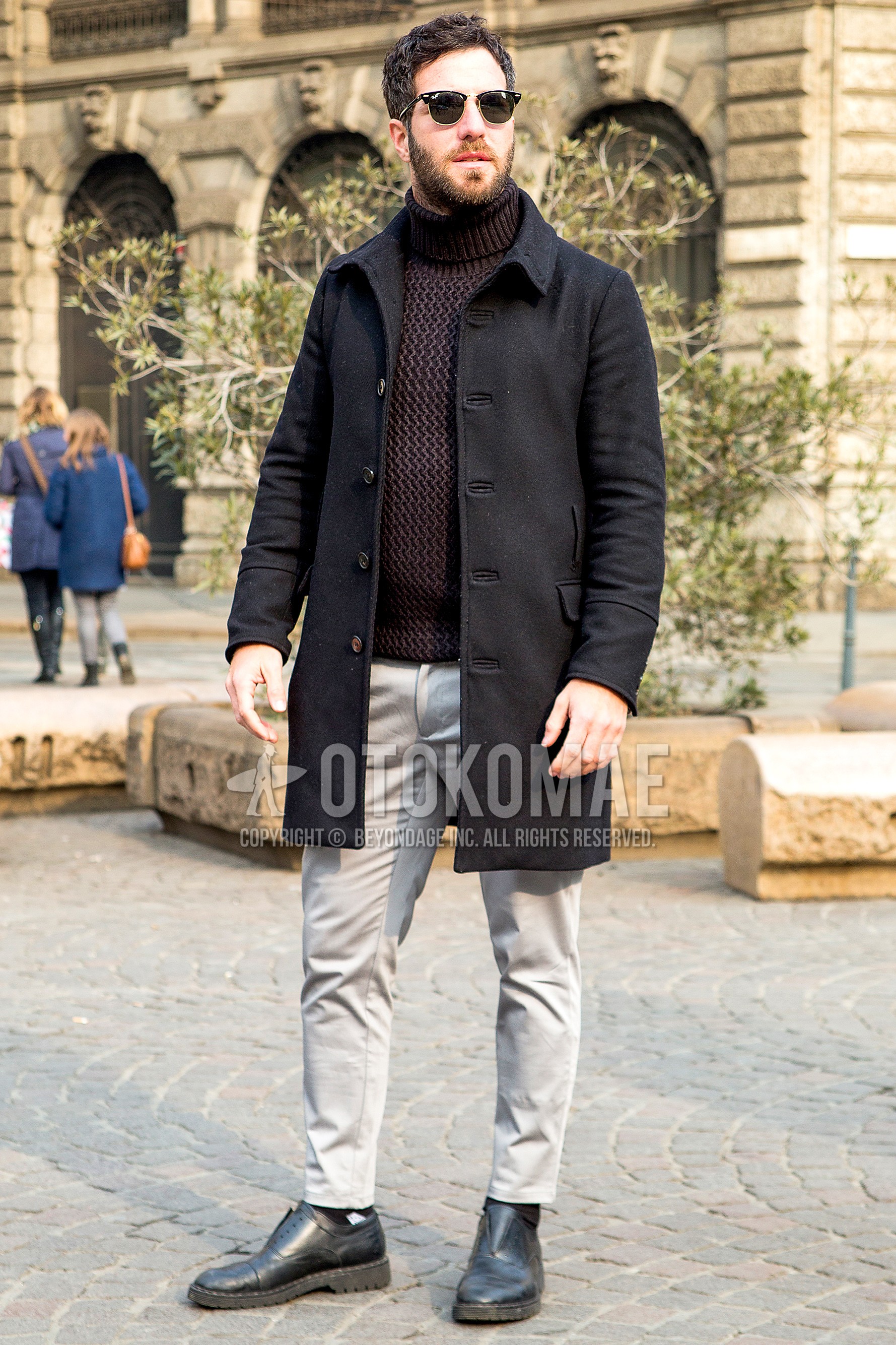Men's autumn winter outfit with plain sunglasses, black plain stenkarrer coat, brown plain turtleneck knit, gray plain chinos, black straight-tip shoes leather shoes.