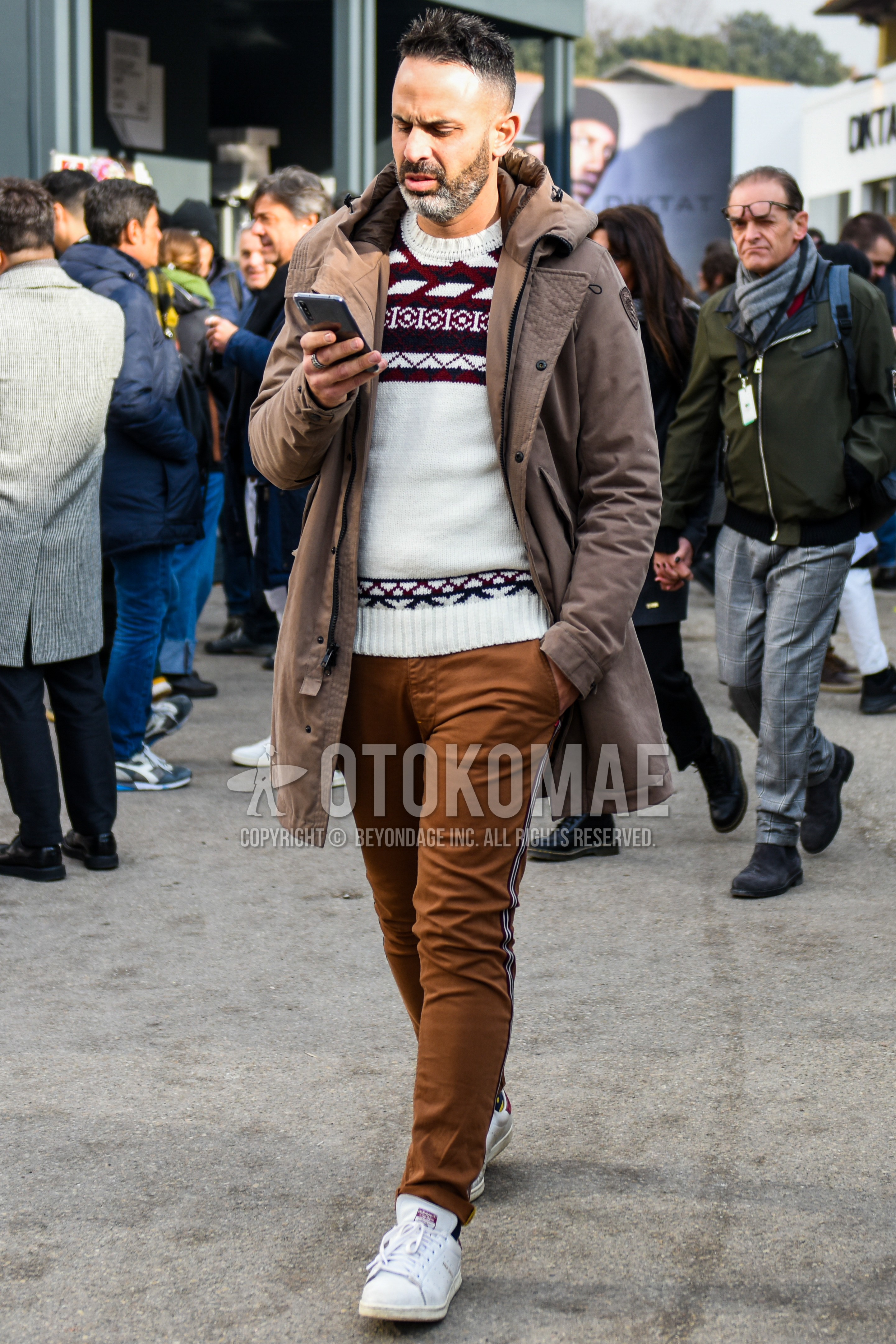 Men's winter outfit with brown plain hooded coat, white tops/innerwear sweater, brown plain sideline pants, white low-cut sneakers.
