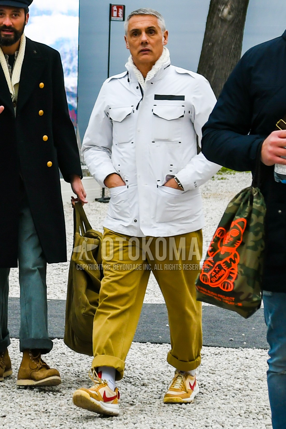 Men's autumn winter outfit with white plain M-65, beige plain chinos, white plain socks, beige low-cut sneakers.