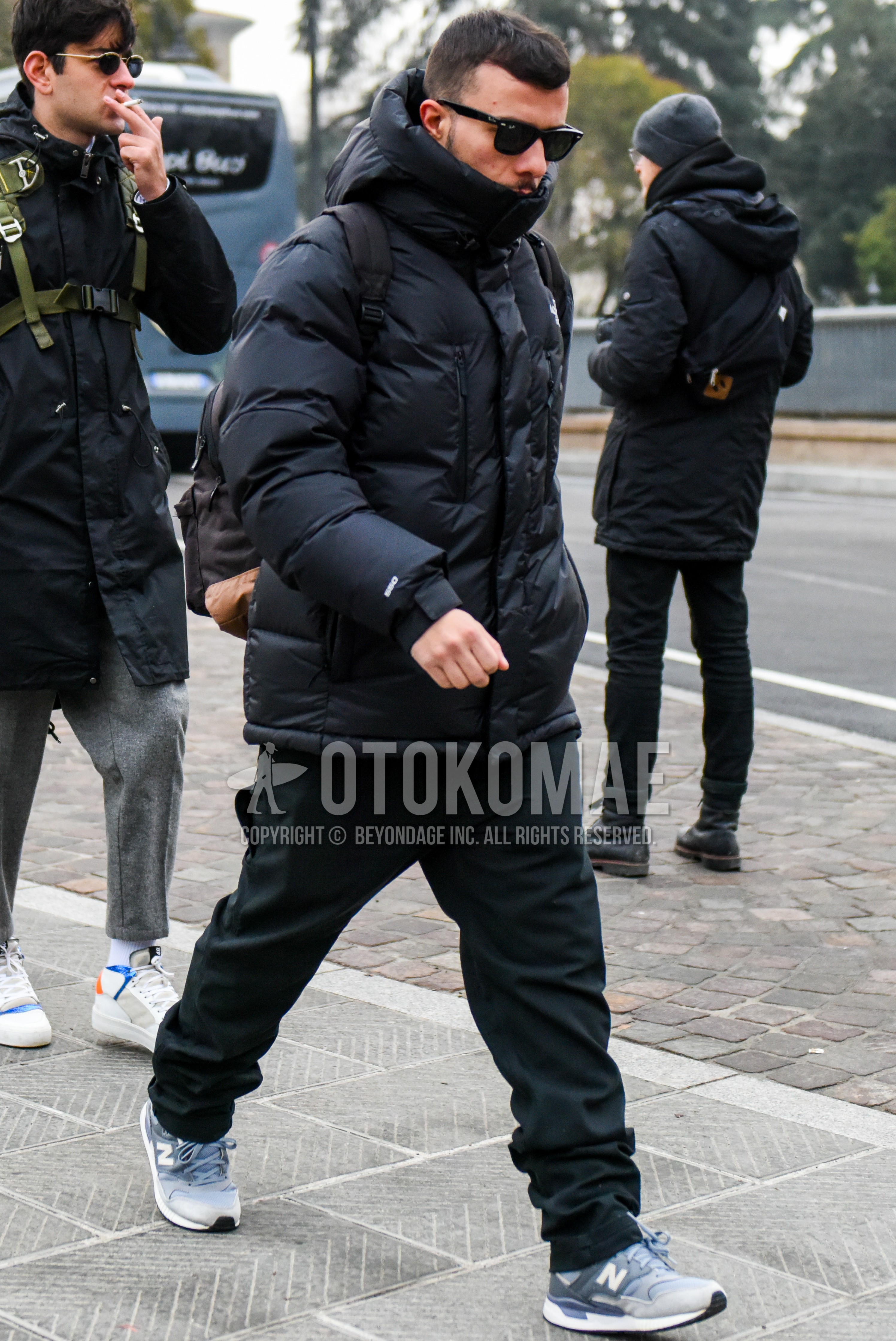 Men's winter outfit with plain sunglasses, black plain down jacket, black plain cotton pants, gray low-cut sneakers.