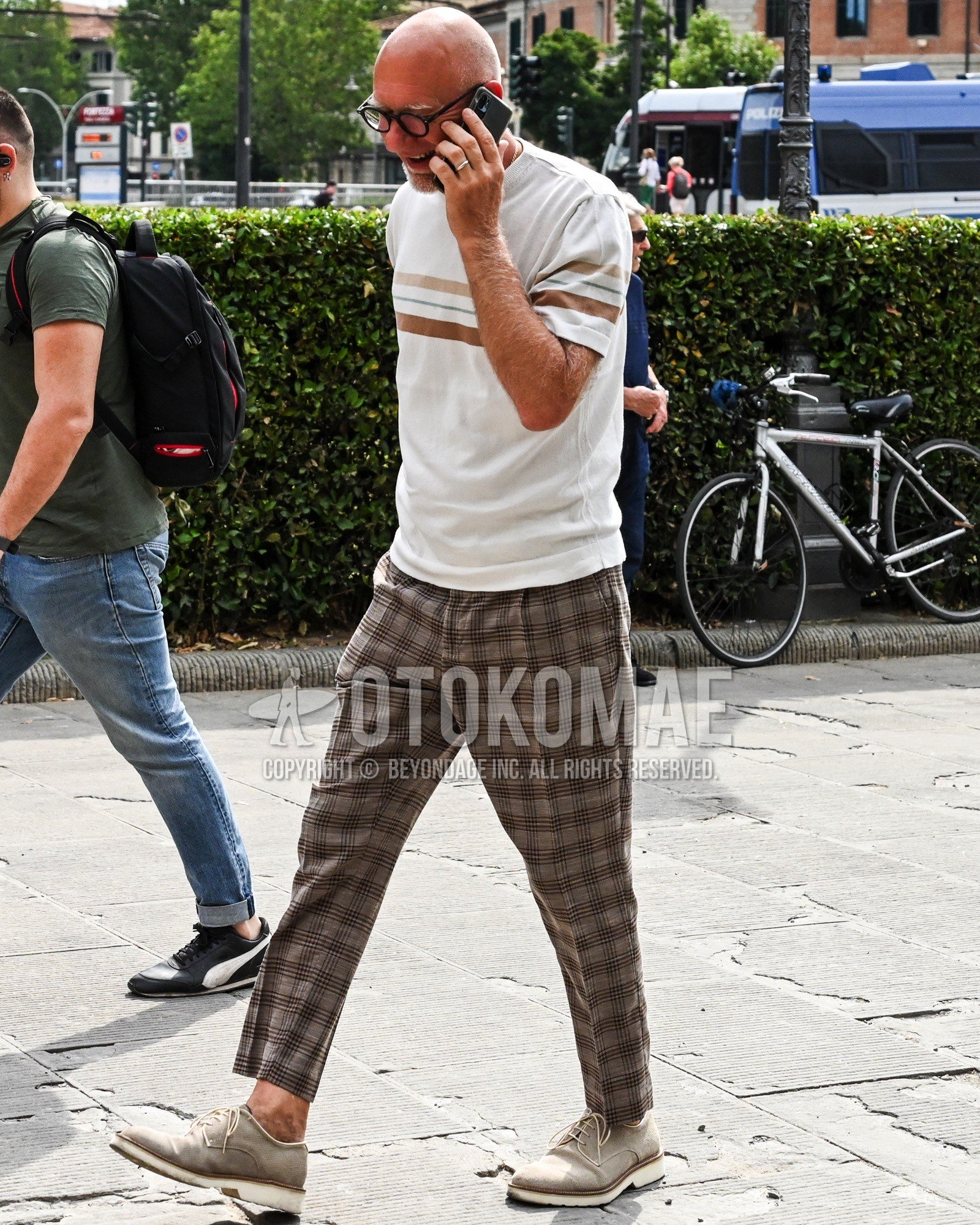 Men's spring summer outfit with white horizontal stripes t-shirt, brown check slacks, beige plain toe leather shoes.
