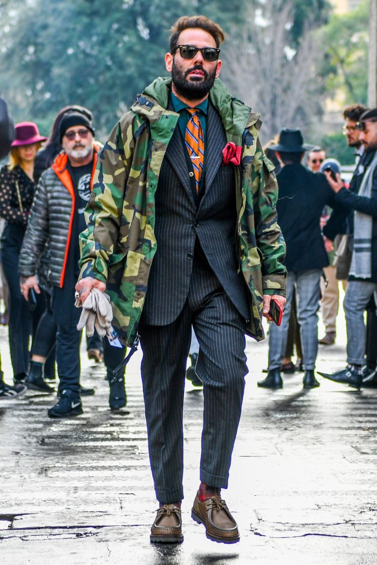 Gray suit with camo outerwear to create a mixed military and dress style