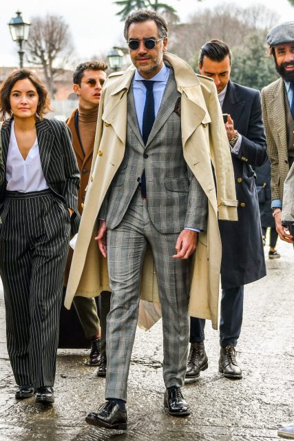 Expressing a dignified gray suit style with a trench coat over the shoulders