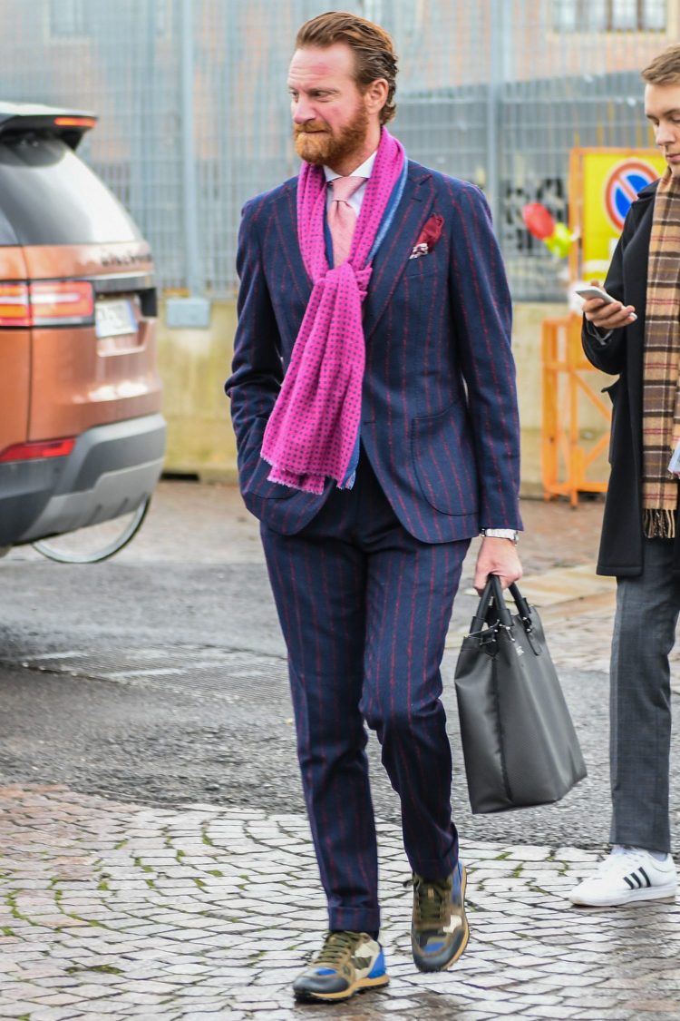 Suit and sneakers style accented with a colorful scarf