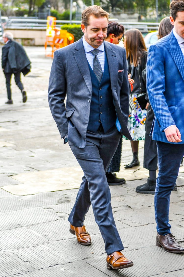 A gray suit coordinate with a navy gilet and just the right amount of accentuation.