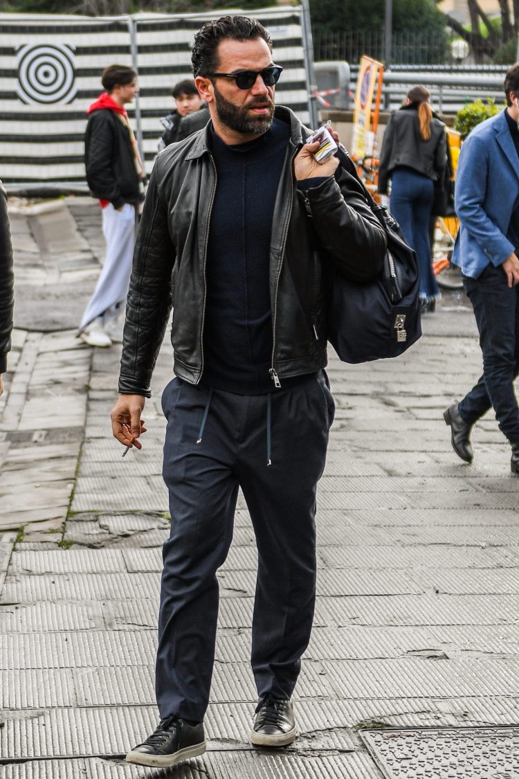 Lightly coordinates a heavy rider's jacket with easy-going gray pants