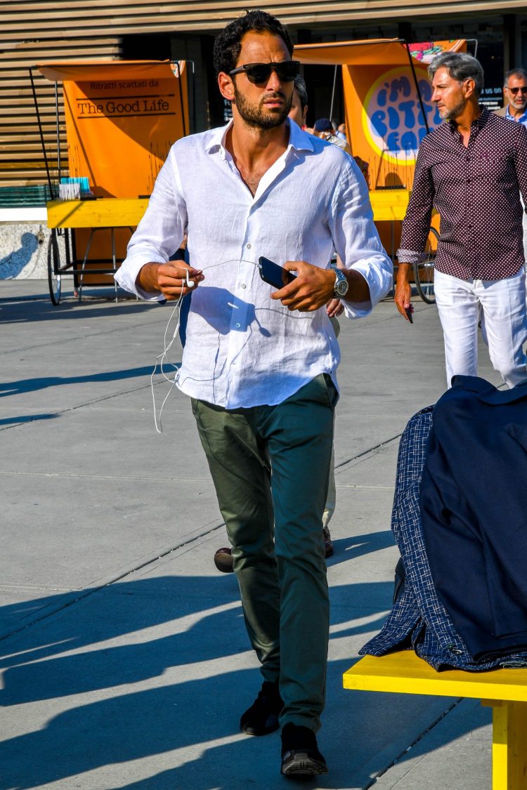 Khaki pants and black sneakers add a casually modern touch