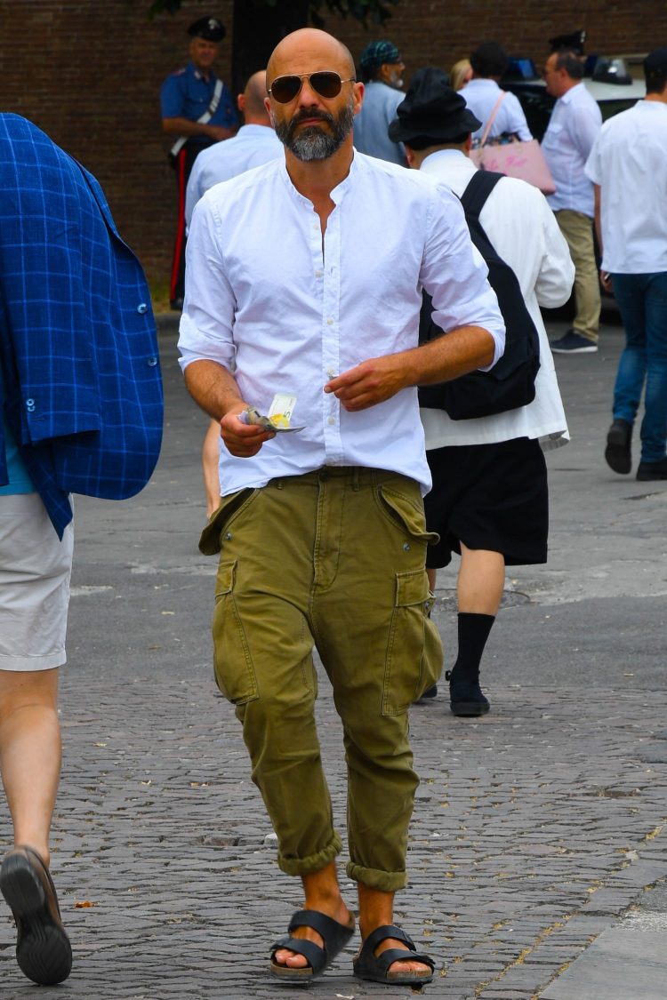 Khaki pants with a unique silhouette are rolled up to a balanced length