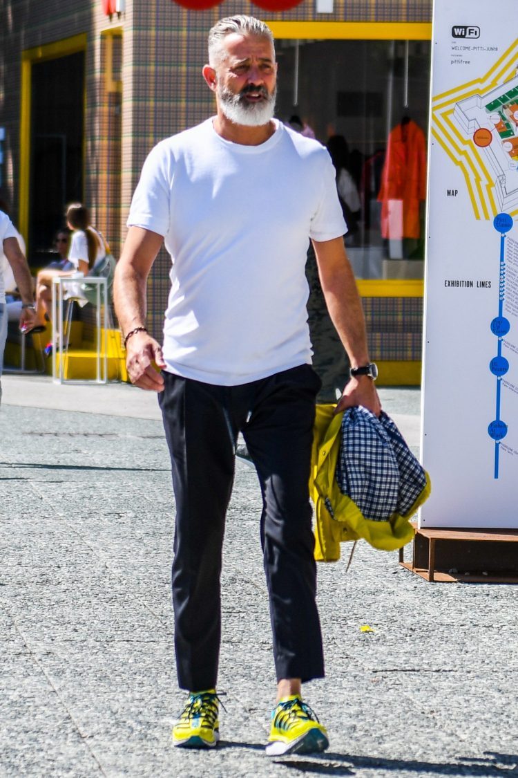 Monotone coordinate of white T-shirt and black pants accented with yellow sneakers
