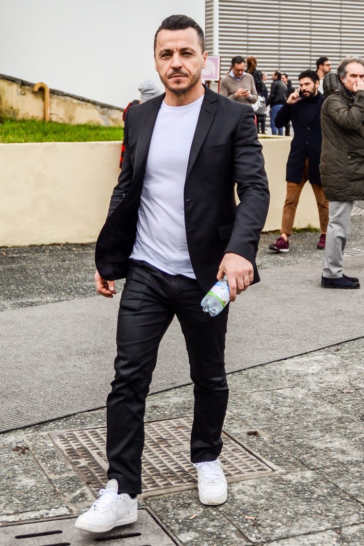 White T-shirt and white sneakers that accentuate the glossy black suit