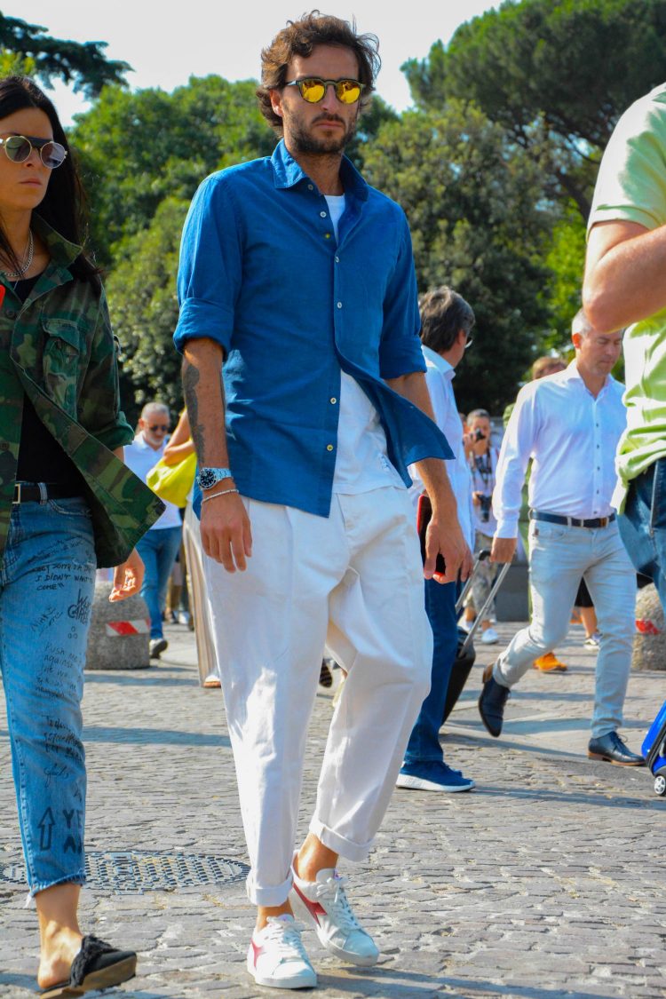 Diadora sneakers highlighting a blue chambray shirt and white pleated pants