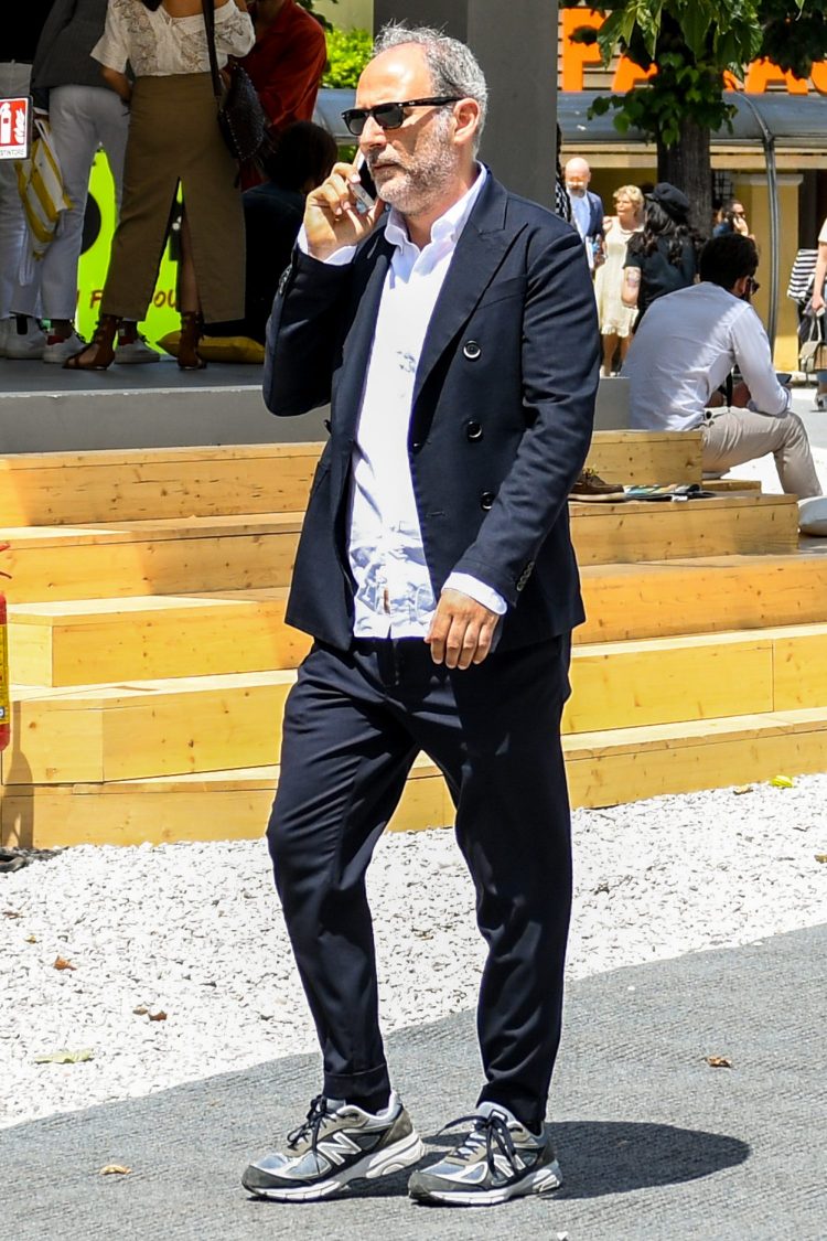 Multi-colored sneakers are coordinated with a black suit to create a light footwear look with a haziness.