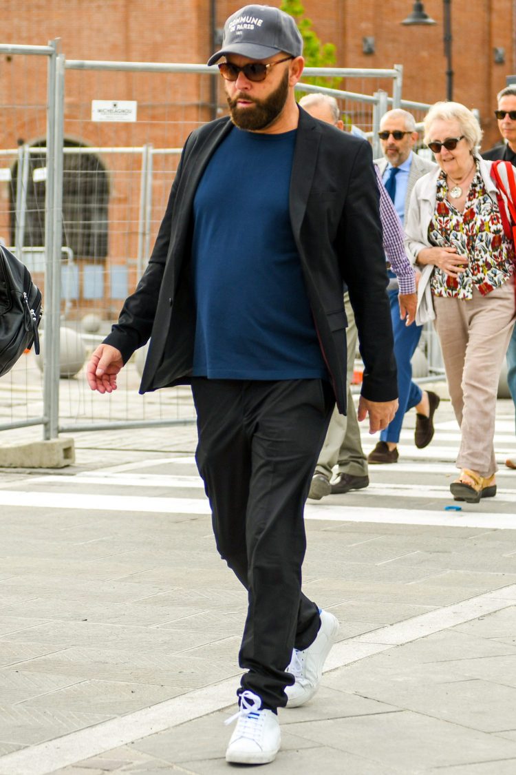 Black suit coordinated with baseball cap and sneakers for street style