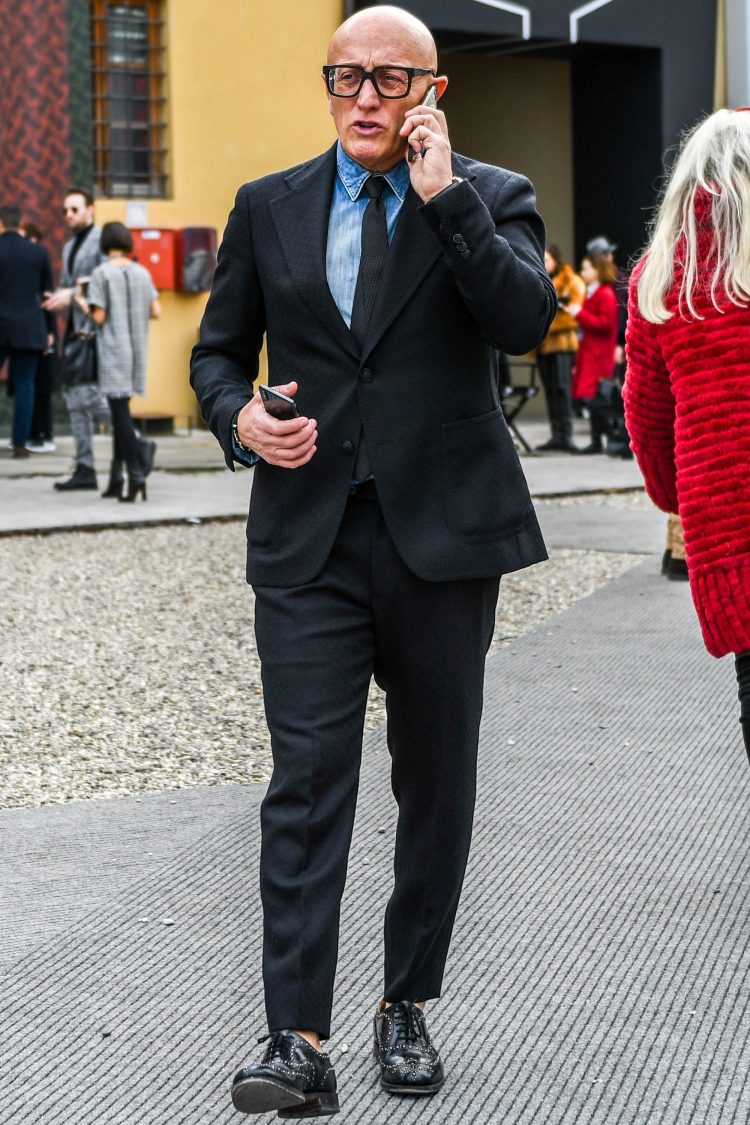 Black suit with tied-up denim shirt to add a mischievous nuance