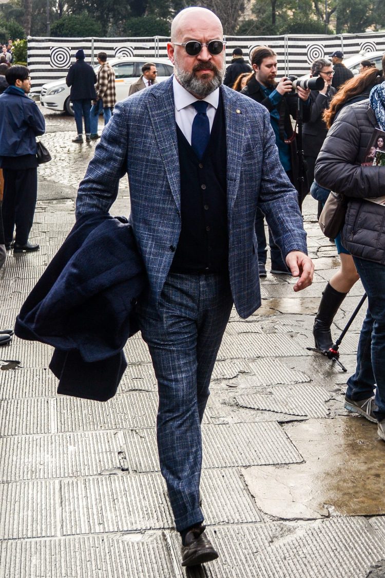Navy suit style coordinated with a knit vest for a moderately casual look