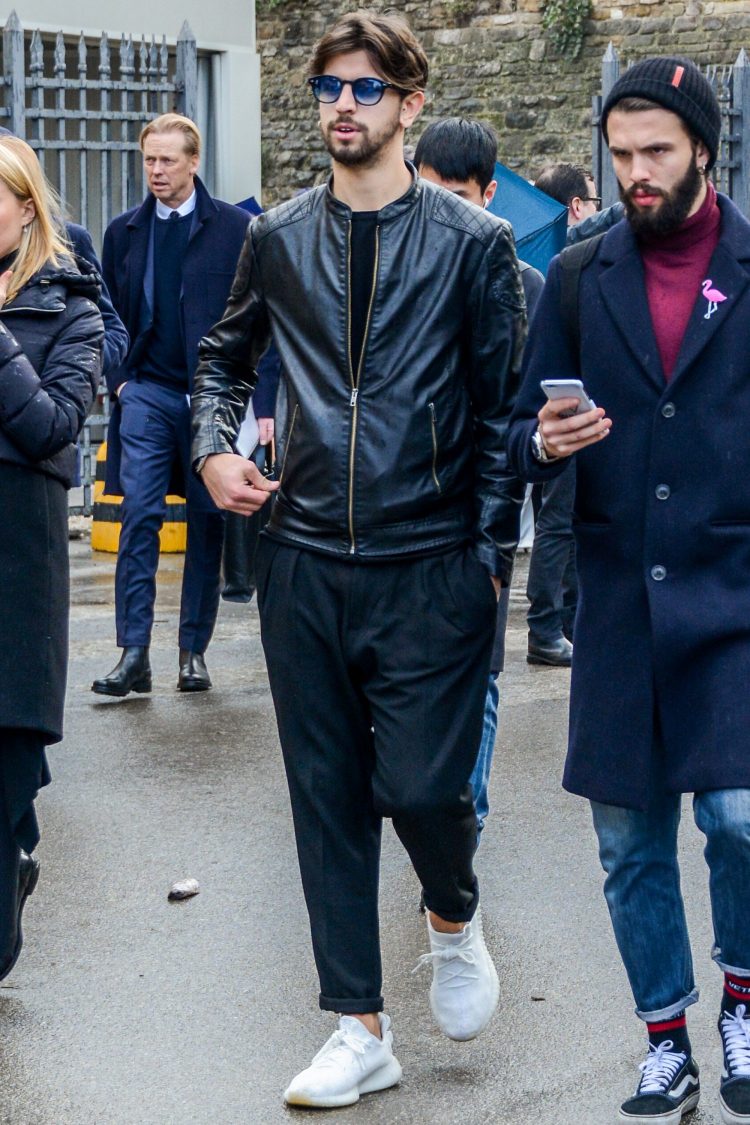 Coordinates a single leather rider's jacket and pleated pants with a crisp silhouette