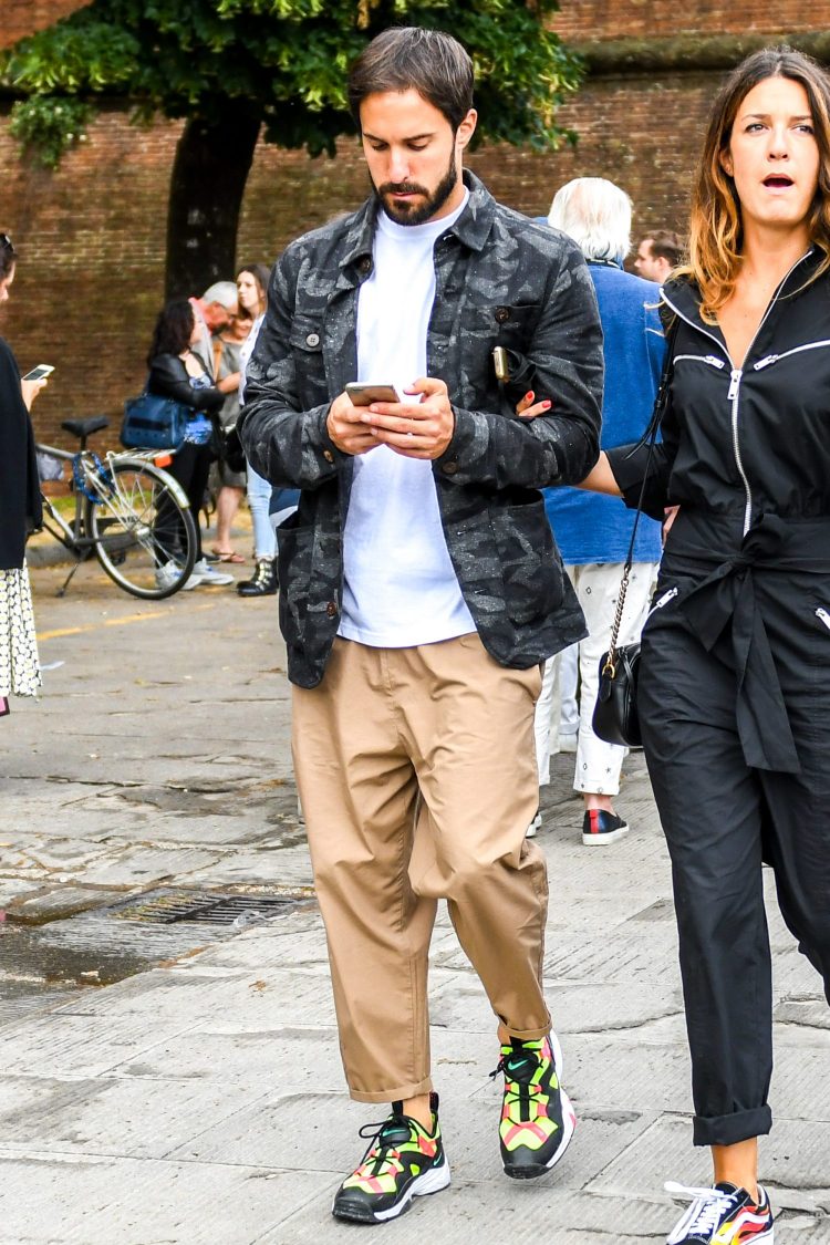 Street style with camouflage print shirt jacket, loose-fitting pants, and colorful sneakers
