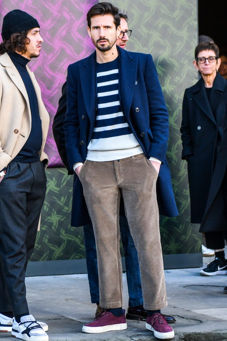 Styling of navy long coat elegantly with fine-ribbed corduroy winter pants