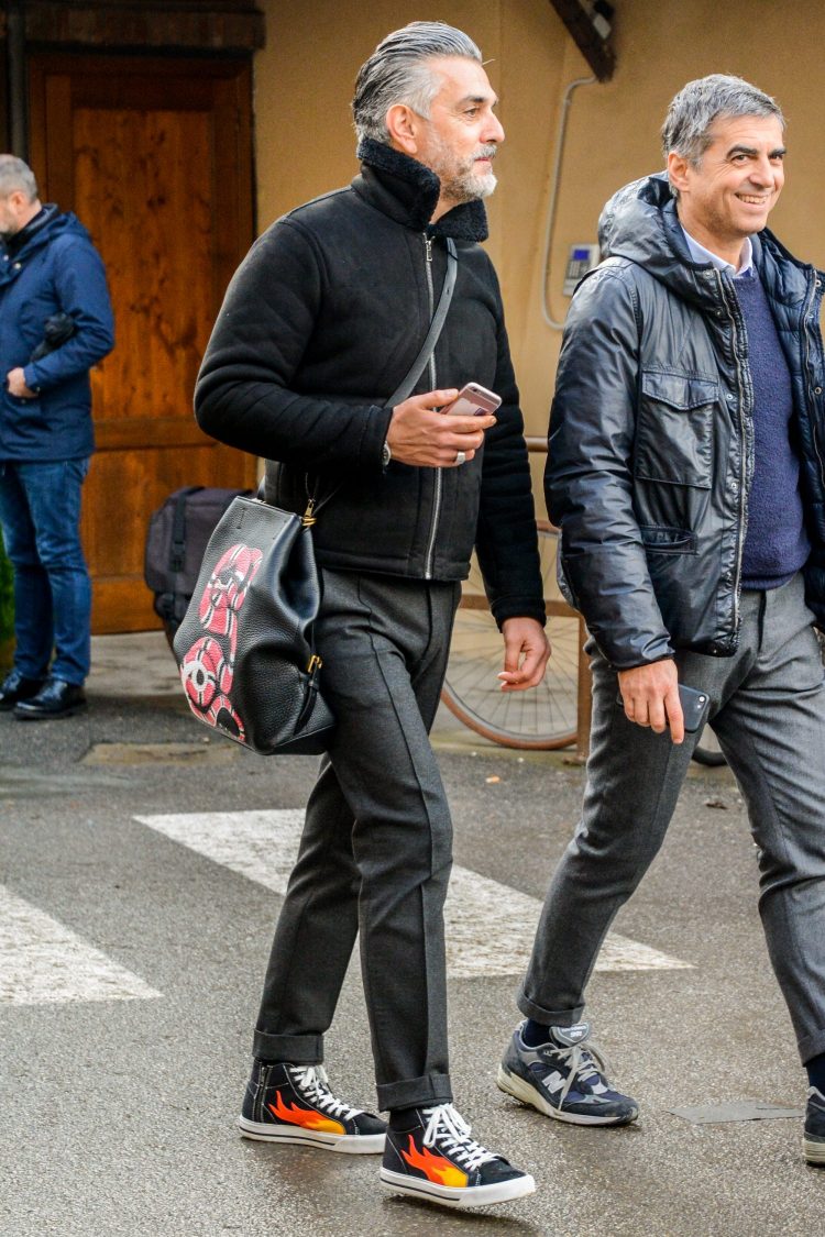 Black mouton boa jacket with graphic accents on the bag and sneakers