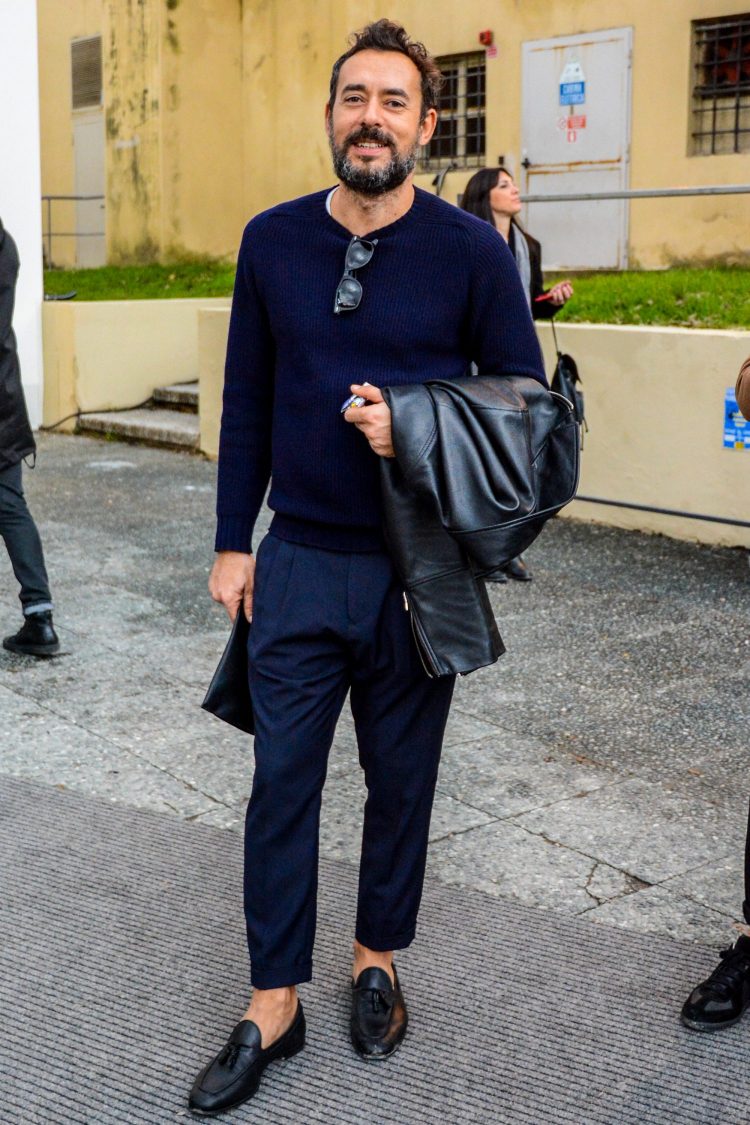 Navy pleated pants coordinate with black leather items for a crisp look