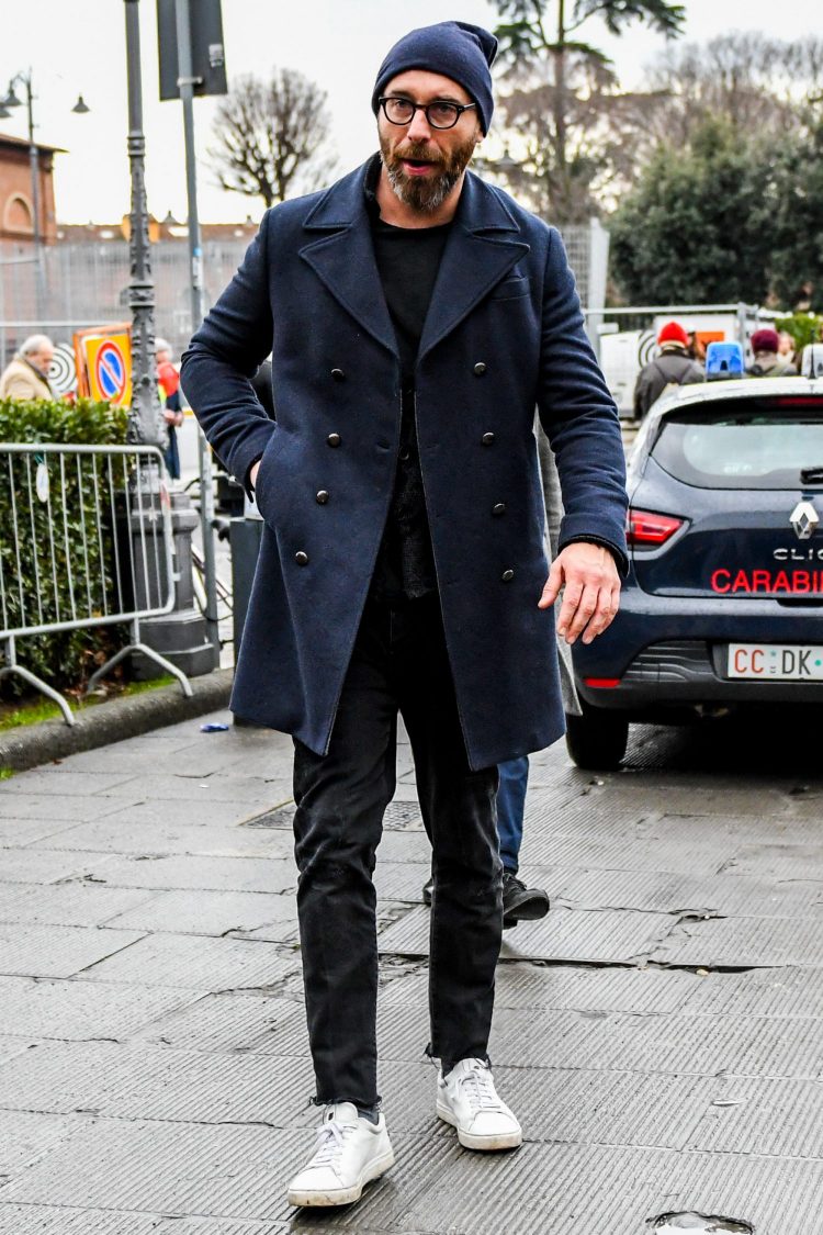 Black pants boost the dignified atmosphere of the navy coat and the cozy look of the white sneakers.