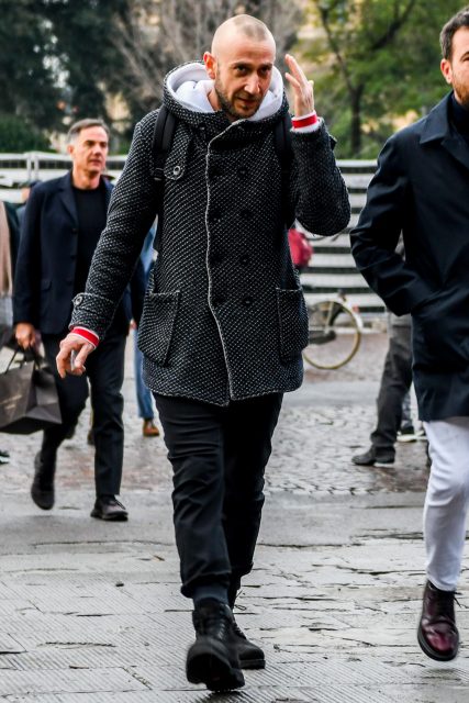 Men's coordinate with black bottoms and black boots highlighting the patterned hooded coat.