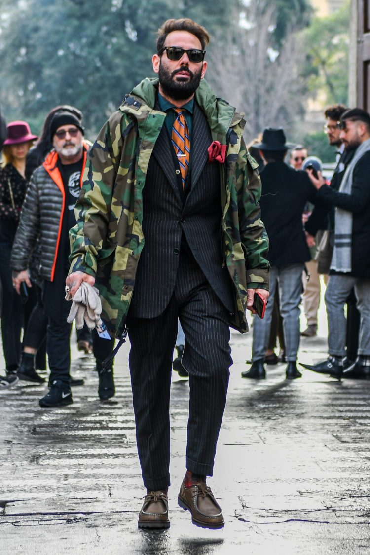 Outdoor and dress mixed with a camouflage mountain parka and charcoal gray striped suit