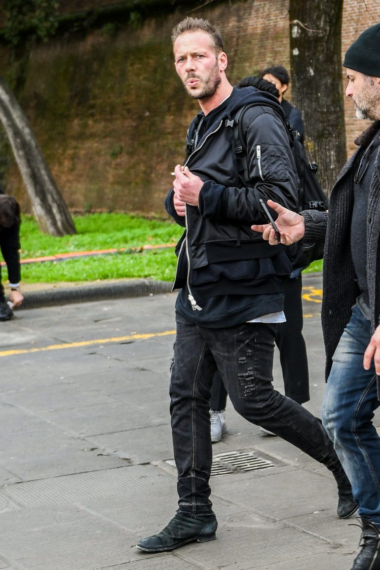 Street style in black damaged jeans with a glimpse of a white T-shirt for a cozy look
