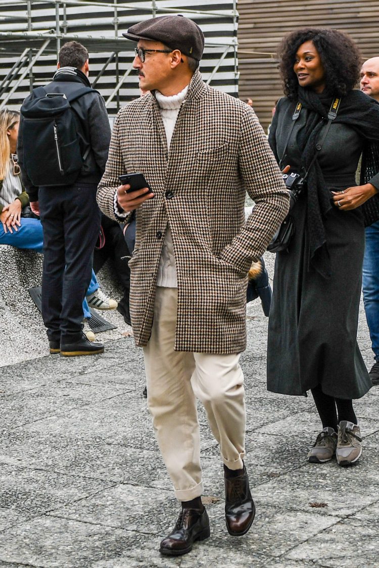 White turtleneck knit with checkered coat and hunting, creating a classic look
