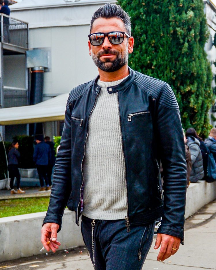 Coordinating sunglasses with mirrored lenses add a modern touch to the men's biker style