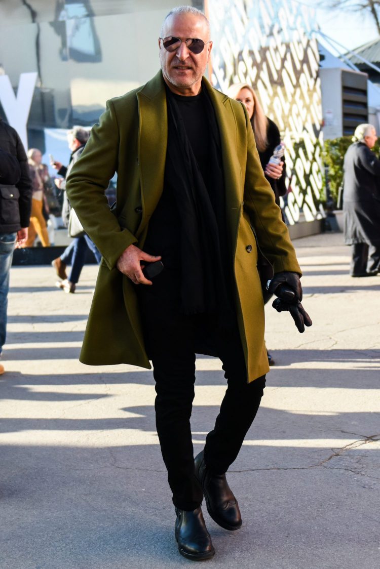 オリーブグリーンのコートを黒コーデに組み込んだ都会的な武骨メンズスタイル