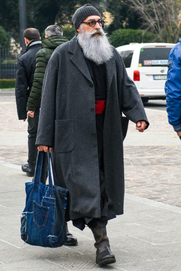 Coordination using a long, loose-fitting gray coat is seasoned with quirky accessories to balance the look.