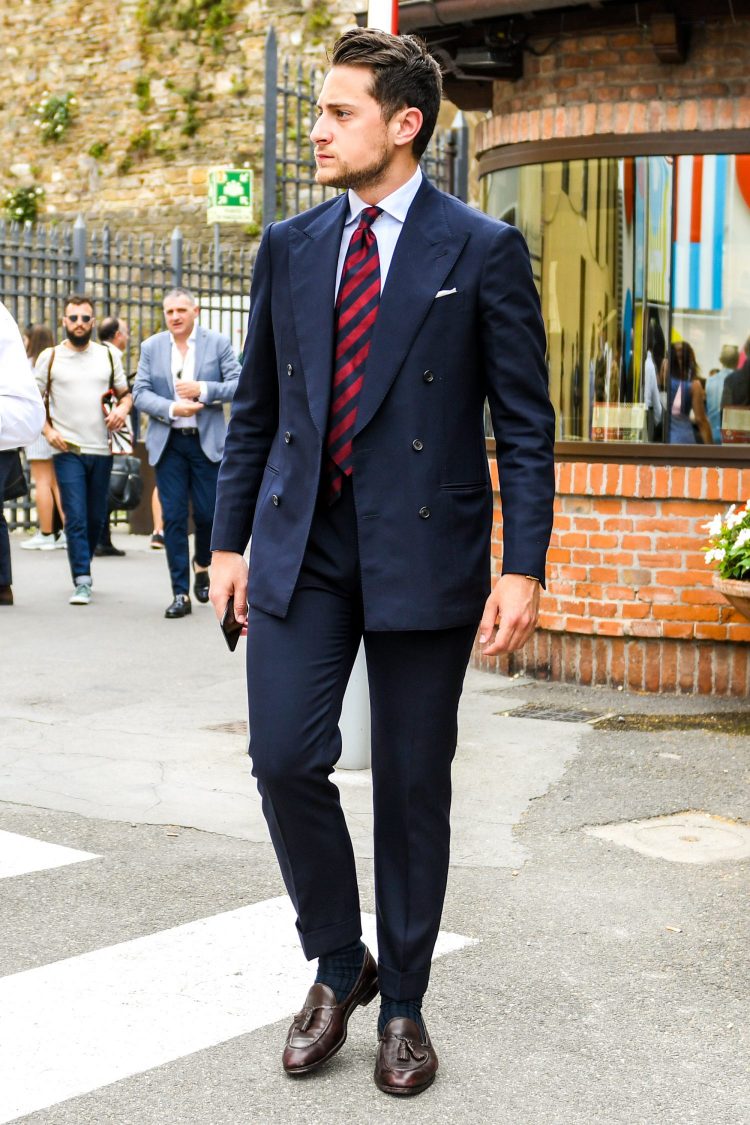 A red regimental tie with a strong impact makes an orthodox navy suit look powerful.