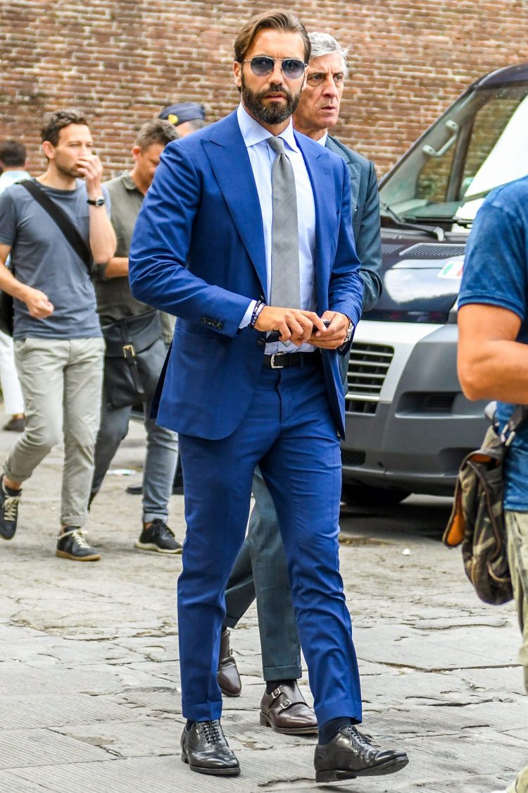 Navy suit with single peaked lapel and silver tie for a formal look