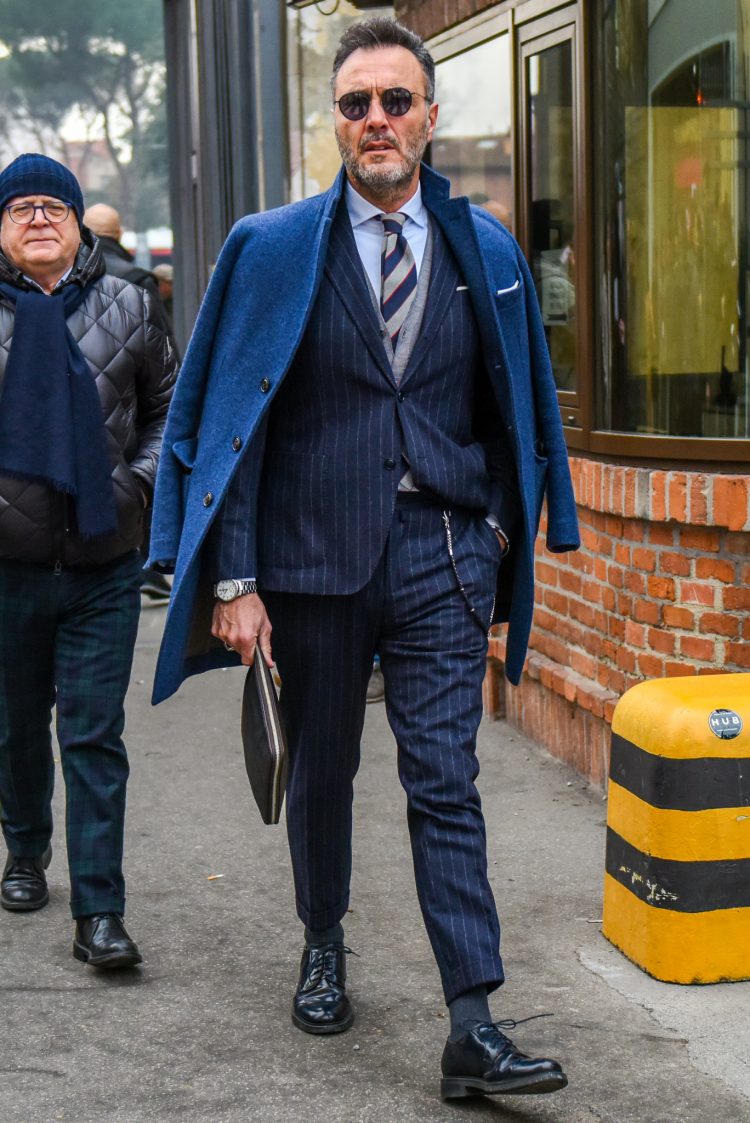 Soften the look of a solid navy suit with a knit cardigan