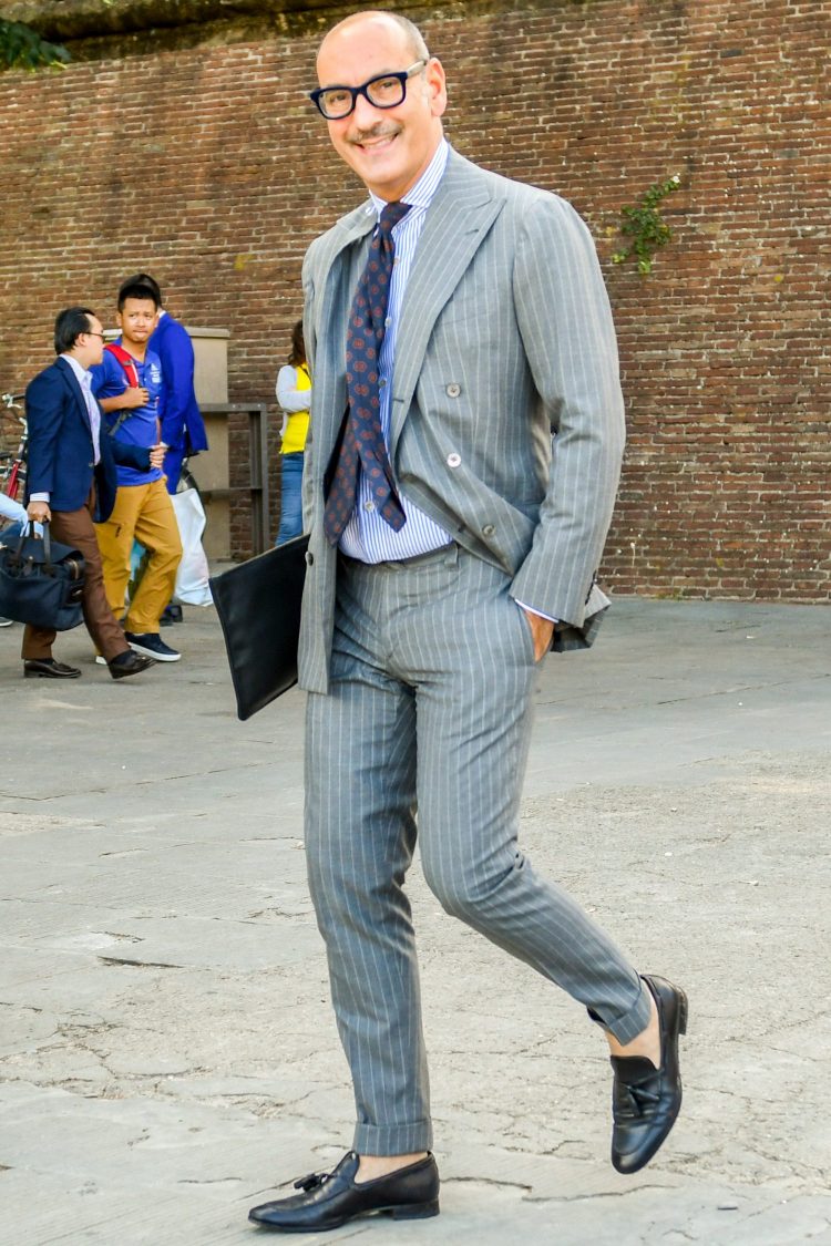 Cleverly dressed in a striped gray suit with a striped shirt
