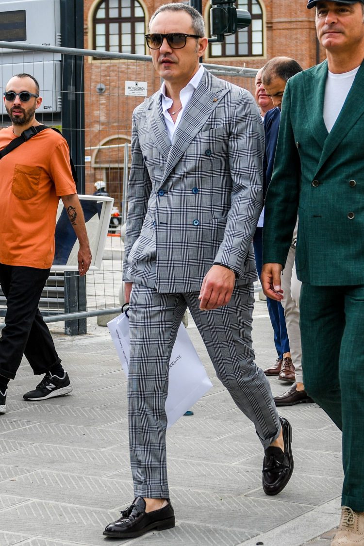 Wearing a double checkered gray suit, he exudes the sex appeal of a man with room to spare.