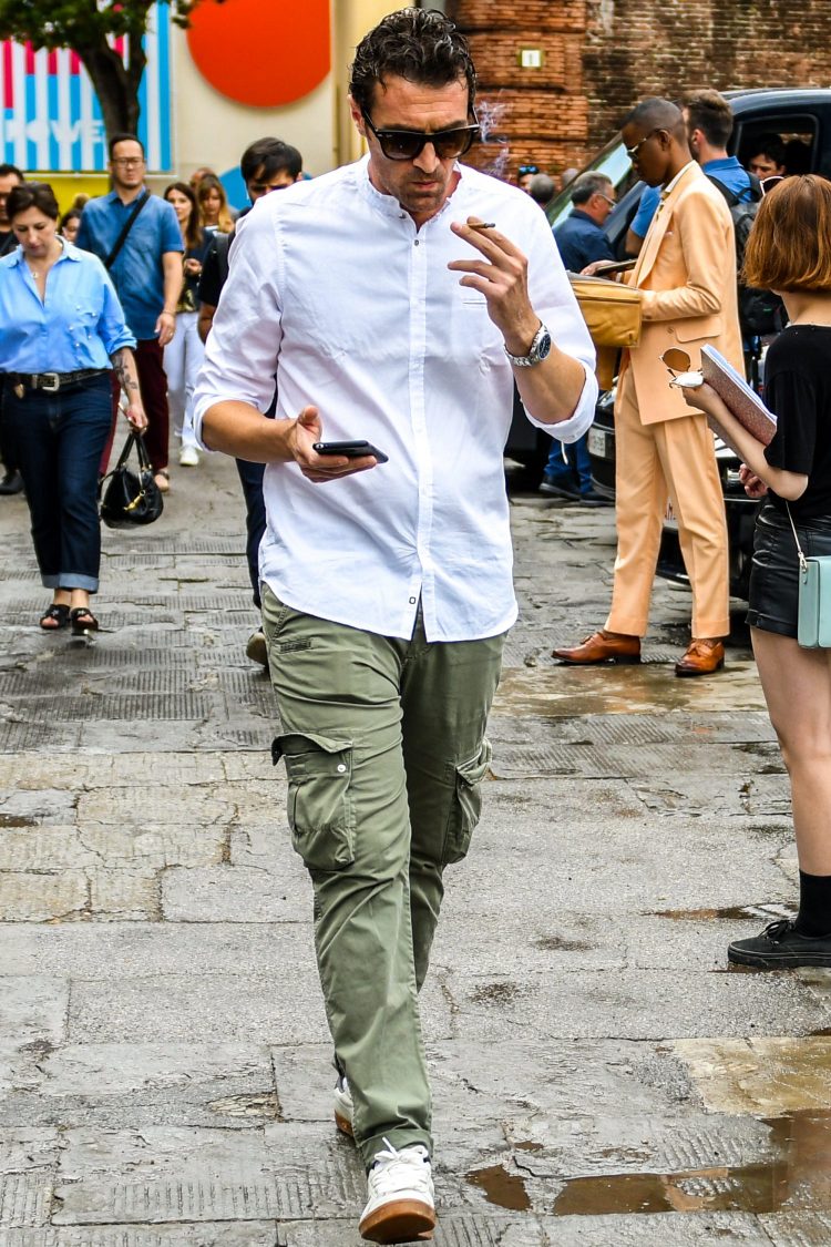 Cargo type khaki pants and a white shirt blending ruggedness and cleanliness in the coordination.
