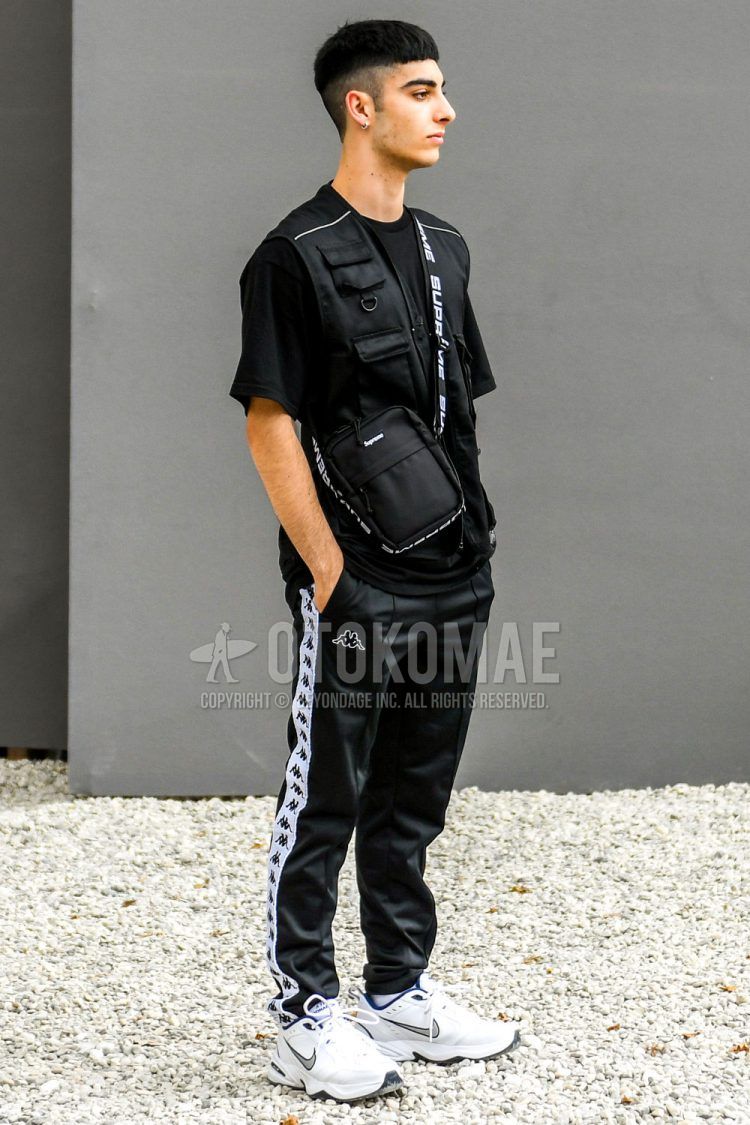 Other solid black, solid black t-shirt, solid black sideline pants from Kappa, white low-cut sneakers from Nike, and a solid black shoulder bag from Supreme in a summer men's coordinate outfit.