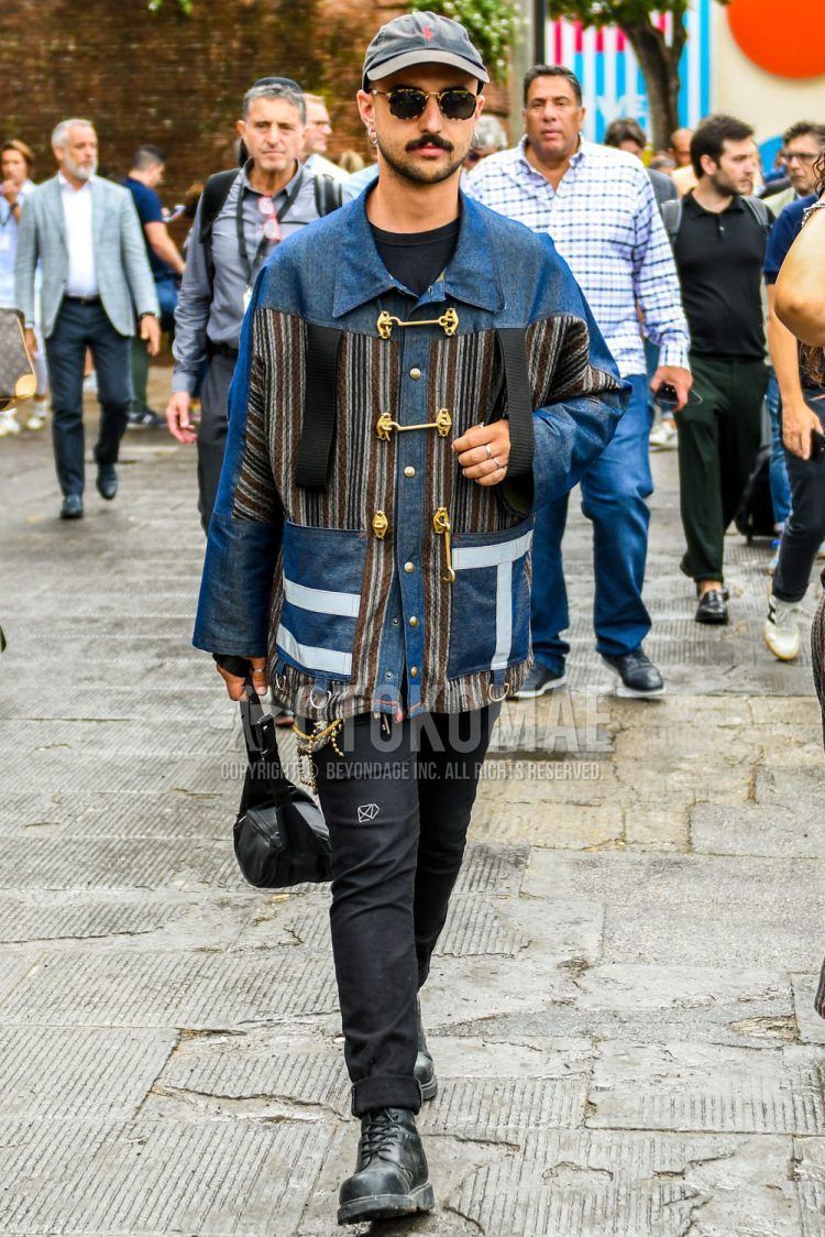 Spring/summer/fall men's coordinate outfit with solid gray baseball cap, brown tortoiseshell sunglasses, solid blue other, solid navy t-shirt, solid black denim/jeans, and black work boots.