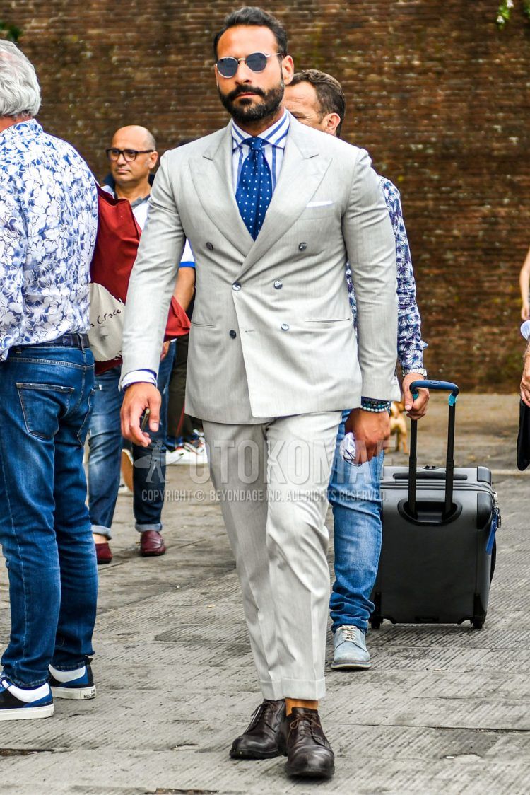 Spring, summer and fall men's coordinate outfit with plain silver sunglasses, plain white shirt, brown plain toe leather shoes, plain brown suit and blue dot tie.