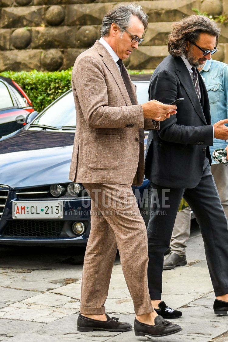 Summer-spring-fall men's coordinate outfit with brown tortoiseshell sunglasses, plain white shirt, brown tassel loafer leather shoes, plain brown suit, and plain brown tie.