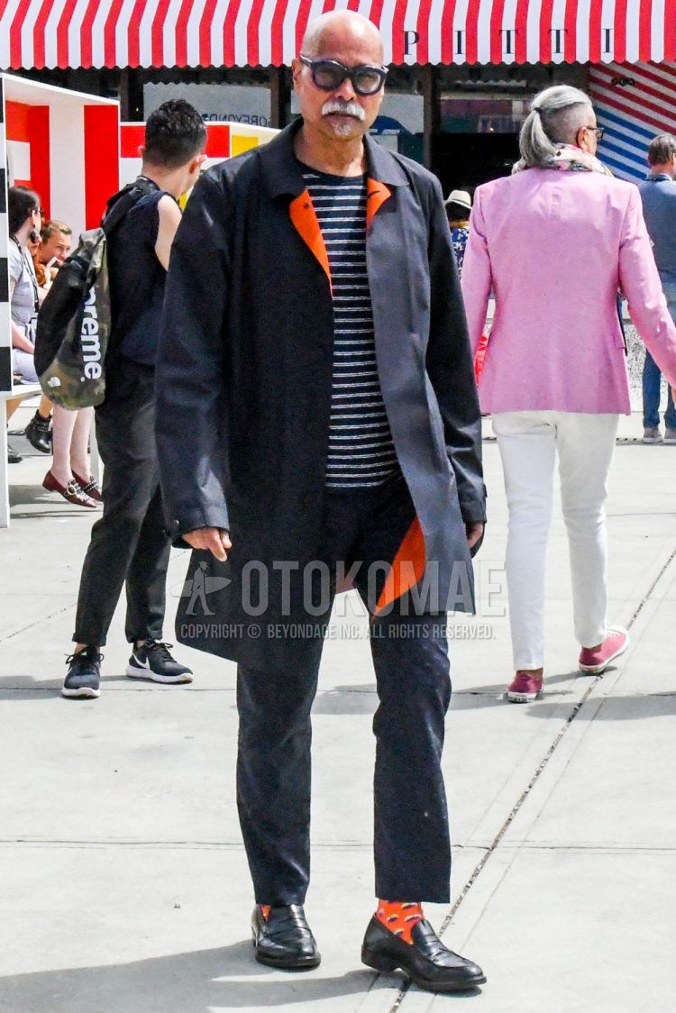 A summer-spring-fall men's coordinate outfit with plain sunglasses, a plain black stainless steel collar coat, a black and white striped T-shirt, plain black ankle pants, orange or other socks, and black coin loafer leather shoes.