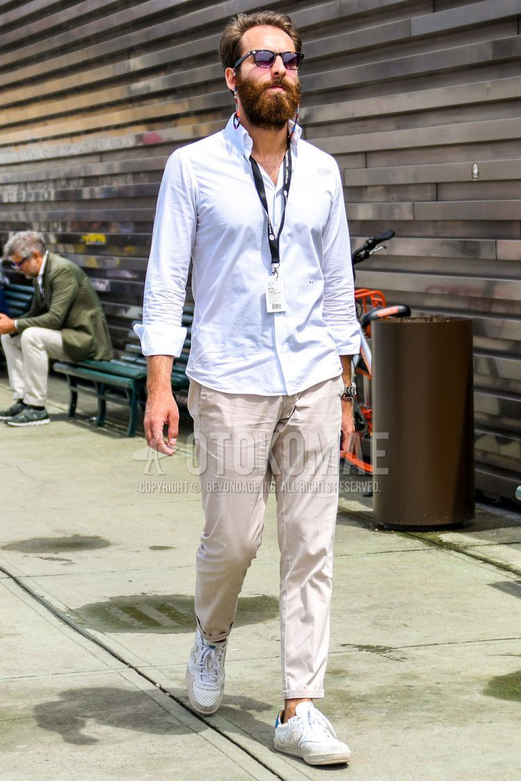 A summer-spring-fall men's coordinate outfit with plain black sunglasses, a plain white shirt, plain beige chinos, and white low-cut sneakers.